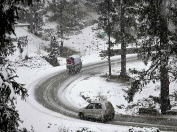 Vehicles plying on a snow-covered road 