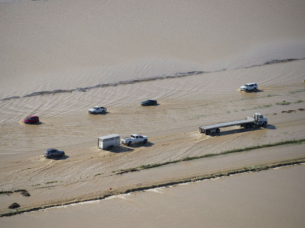 Commuters make their way through flood waters