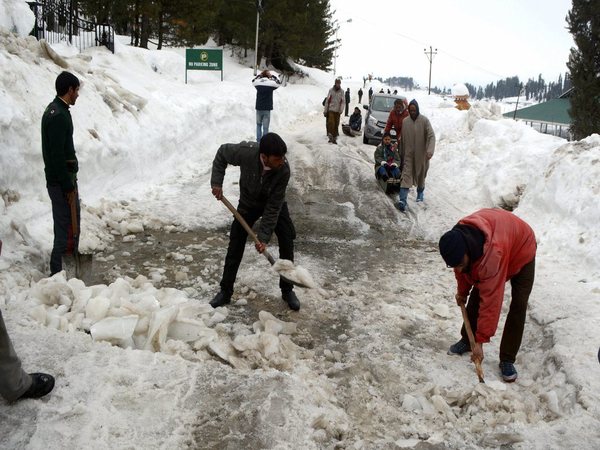 Government labourers clear snow from a road