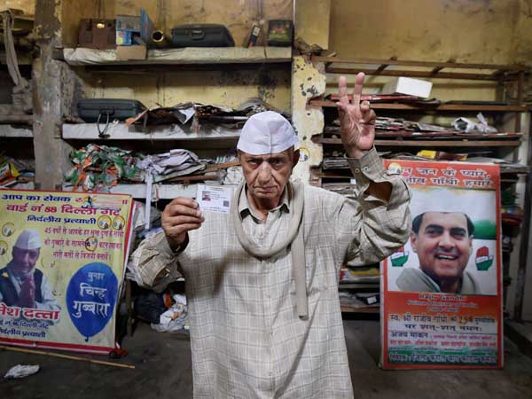 Independent candidate Ramesh Datta flashes victory sign as he leaves to cast his vote.