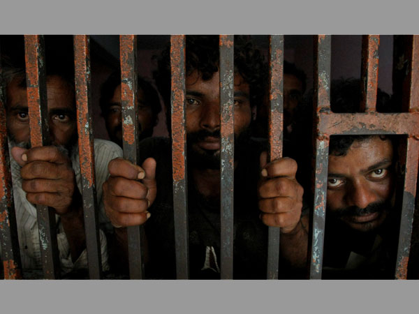 Arrested Indian fishermen look out at a lock up at a police station in Karachi, Pakistan. Arrested Indian fishermen look out at a lock up at a police station in Karachi, Pakistan.