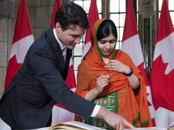 Prime Minister Justin Trudeau shows Malala Yousafzai the guest book after arriving on Parliament Hill for her Honorary Canadian Citizenship ceremony in Ottawa. Prime Minister Justin Trudeau shows Malala Yousafzai the guest book after arriving on Parliament Hill for her Honorary Canadian Citizenship ceremony in Ottawa.