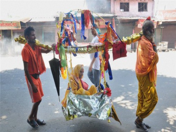 Devotees carrying a woman in a Kanwar in Moradabad
