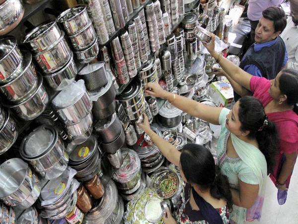 Women buy utensils at a market in Jammu