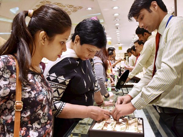A woman buys gold jewellery in a shop on the occasion of Akshaya Tritiya