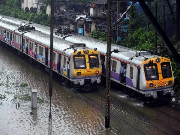 Suburban trains chug on water-logged tracks during heavy rains in Mumbai
