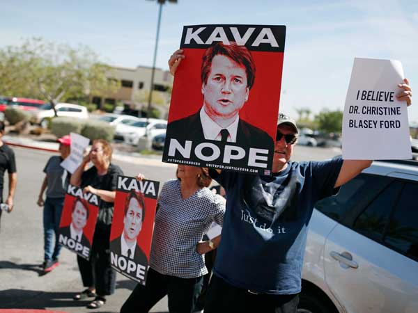 People hold signs during a protest against Kavanaugh outside the offices of Sen. Dean Heller, R-Nev. in Las Vegas. People hold signs during a protest against Kavanaugh outside the offices of Sen. Dean Heller, R-Nev. in Las Vegas.