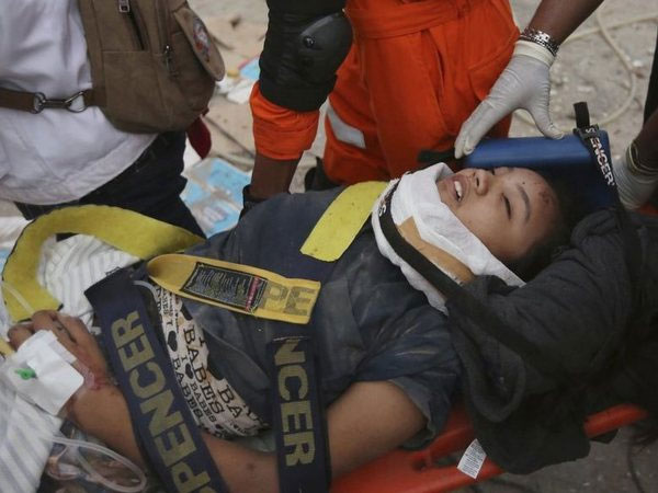 Rescuers carry survivor from a restaurant building damaged by the earthquake