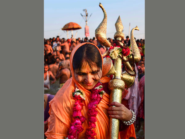 A Sadhvi of Juna Akhara takes a holy dip holding a trident