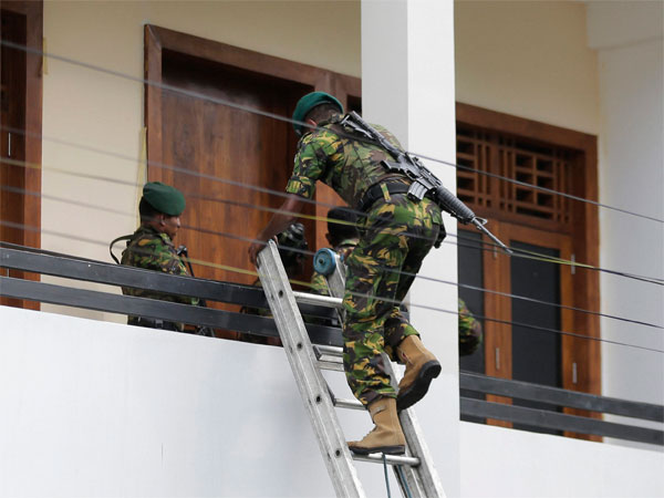 A Sri Lankan police commando enters a house suspected to be a hideout of militants following a shoot out in Colombo, Sri Lanka A Sri Lankan police commando enters a house suspected to be a hideout of militants following a shoot out in Colombo, Sri Lanka