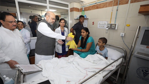 Home Minister Amit Shah distributing food to a patient at AIIMS