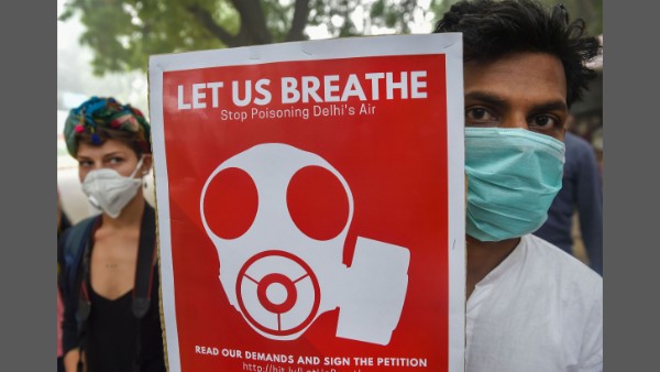 Members of DYFI and JSA (Delhi) wearing masks display placards during protest march