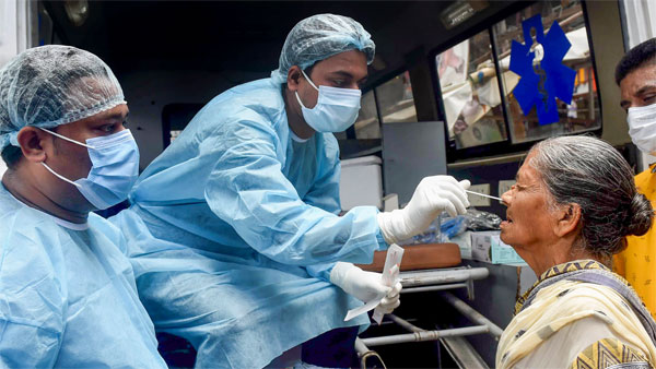 A healthcare worker takes a swab sample of a woman for Covid-19 testing amid a surge in coronavirus cases A healthcare worker takes a swab sample of a woman for Covid-19 testing amid a surge in coronavirus cases