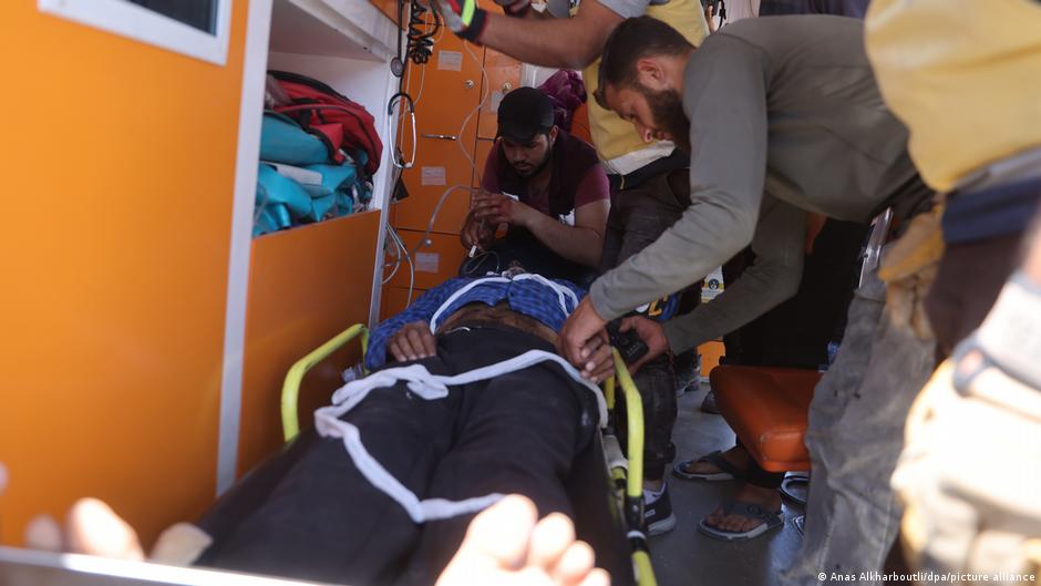 Members of the White Helmets treat an injured person following the airstrike by Russian warplanes in Jisr al-Shughur
