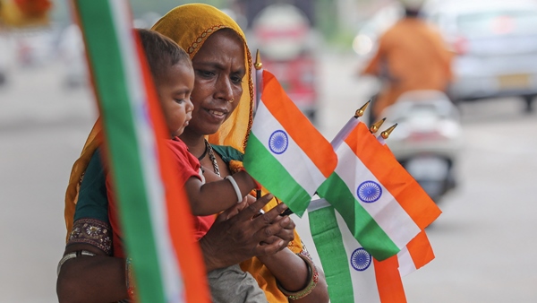 A woman sells miniature Indian flags ahead of the Independence Day celebration, in Jammu. (Photo credit: PTI)
