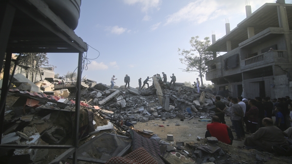Palestinians stand by the building destroyed in an Israeli airstrike in Rafah, Gaza Strip (PTI Photo)