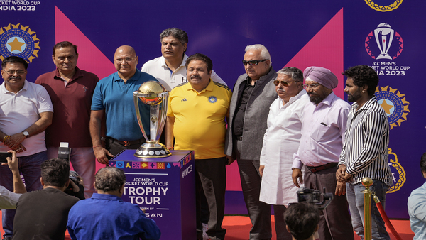 BCCI vice-president Rajeev Shukla (in yellow t-shirt) with officials and school children poses with ICC World Cup Trophy during its tour at Arun Jaitley Stadium, in New Delhi (PTI Photo)