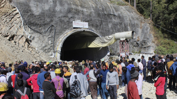 People watch rescue and relief operations at the site of an under-construction road tunnel that collapsed in mountainous Uttarakhand state, India