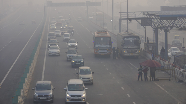 Vehicles ply on NH-24 amid fog on a cold winter morning, in New Delhi