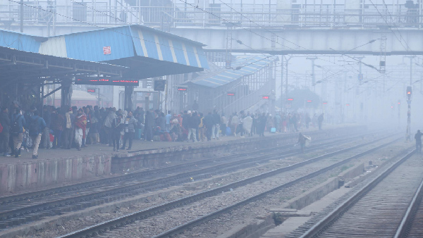 Commuters wait for trains during a foggy winter morning at Mathura Junction railway station