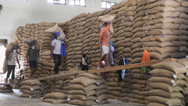 Labourers carry sacks of rice after unloading them from a wagon train at Food Corporation of India (FCI) godown