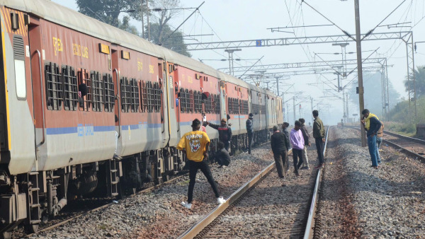 Passengers wait on tracks following a disruption in train services on the Howrah-Mumbai route after members of the banned CPI (Maoist) blew up a portion of railway tracks, at Chaibasa in West Singhbhum district, Jharkhand