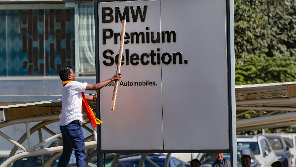 A signboard of a business establishment being vandalised by a Karnataka Rakshana Vedike (Narayana Gowda faction) activist, in Bengaluru