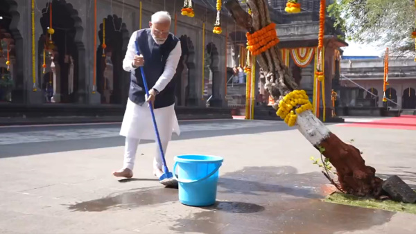 Prime Minister Narendra Modi takes part in a swachhata drive during a visit to Shri Kalaram temple, in Nashik