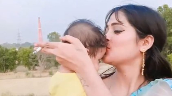 Woman Smoking While Holding Infant