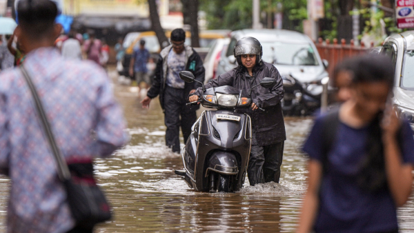 A commuter makes his way through a waterlogged road after rains in Mumbai Thursday July 25 2024