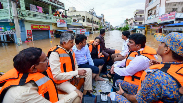 Andhra Pradesh Chief Minister N Chandrababu Naidu with others during a visit to a flood-affected area in Vijayawada