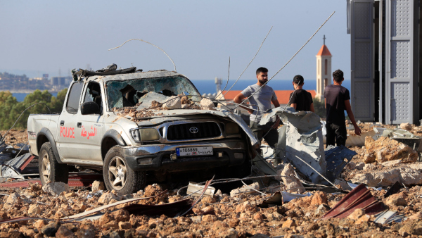People gather near a damaged car at the site of an Israeli airstrike that hit a hangar in the southern town of Jiyeh Lebanon Wednesday Sept 25 2024