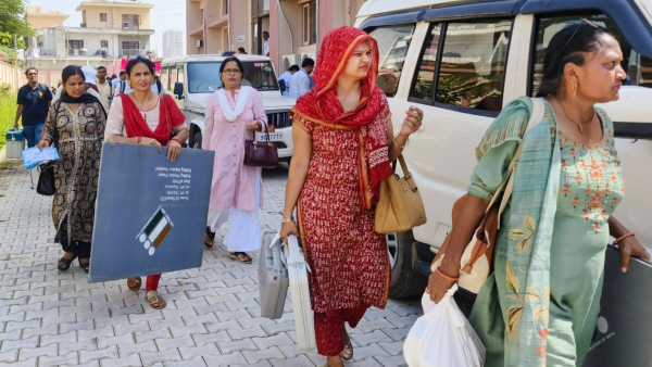 Polling officials leave for their their respective polling stations on the eve of the Haryana Assembly elections in Faridabad district
