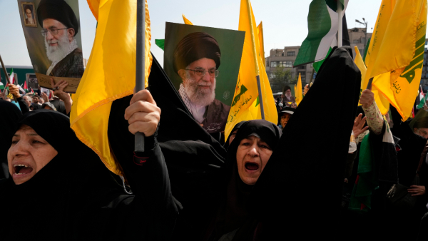 Iranian worshippers chant slogans as they hold up posters of Supreme leader Ayatollah Ali Khamenei