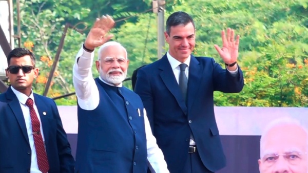 Prime Minister Narendra Modi and Spanish Prime Minister Pedro Sanchez wave during a roadshow in Vadodara