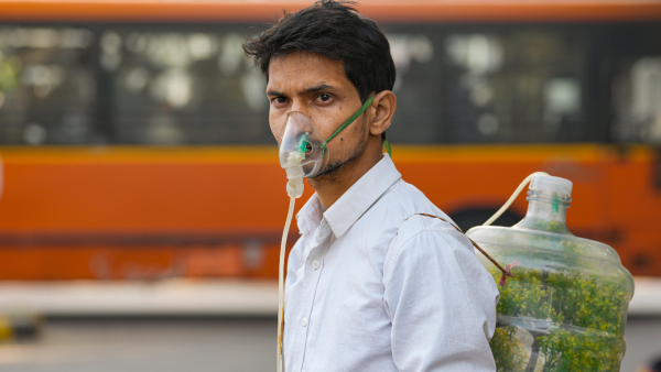A protester wears an oxygen mask during a protest against air pollution near the Parliament House complex in New Delhi Wednesday Nov 27 2024