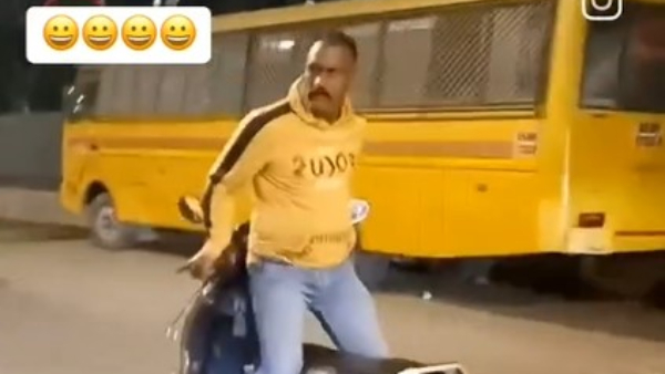 Man Rides Two-Wheeler Standing Backwards Man Rides Two-Wheeler Standing Backwards