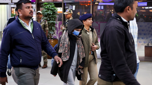 Security personnel escort a Gujarat native deported from US after she was brought to the Ahmedabad airport Thursday Feb 6 2025 A US military plane brought 104 deported Indians to Amritsar on Wednesday