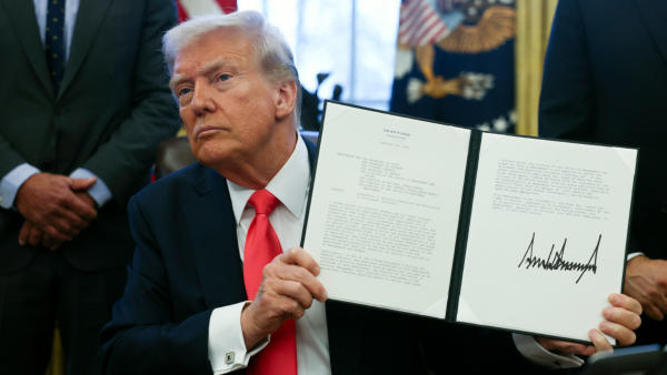 US President Donald Trump holds a signed memorandum regarding revoking security clearances in the Oval Office at the White House in Washington Tuesday Feb 25 2025