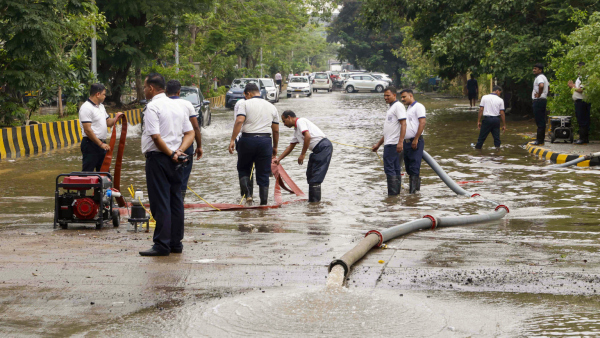 Firemen drain water from a flooded road after heavy monsoon rainfall in Navi Mumbai Tuesday May 27 2025