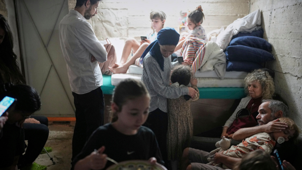 Israelis take shelter in a basement as a siren sounds a warning following missile launches from Iran in Jerusalem Sunday June 15 2025