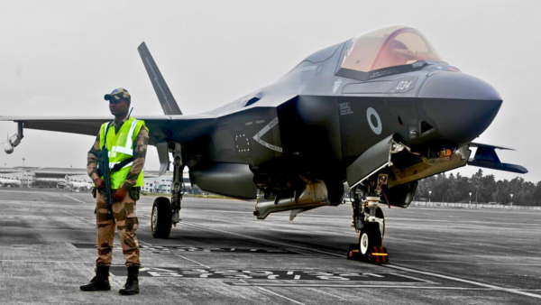 a CISF personnel stand guard near the British F-35 fighter jet that made an emergency landing after running low on fuel at the Thiruvananthapuram International Airport on Saturday night