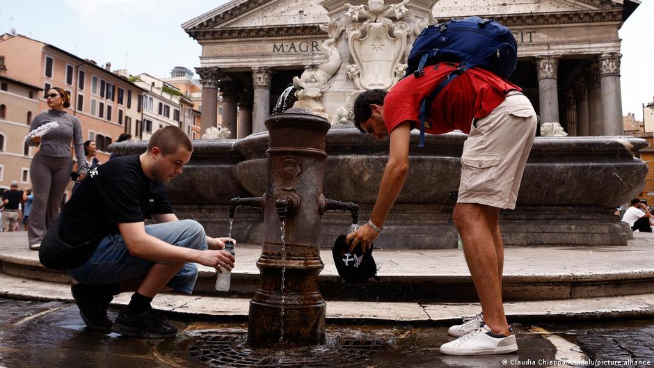 Tourists filling up their water bottles at one of the famous Nasoni outside the historic Pantheon in Rome