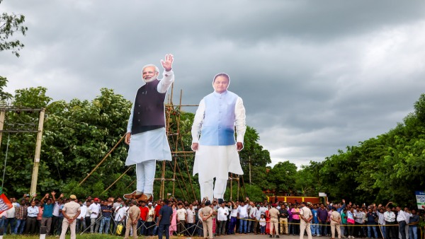 In this image released on Sept 27 2025 people stand near large cutouts of Prime Minister Narendra Modi and Odisha Chief Minister Mohan Charan Majhi at the venue of a public rally in Jharsuguda Odisha