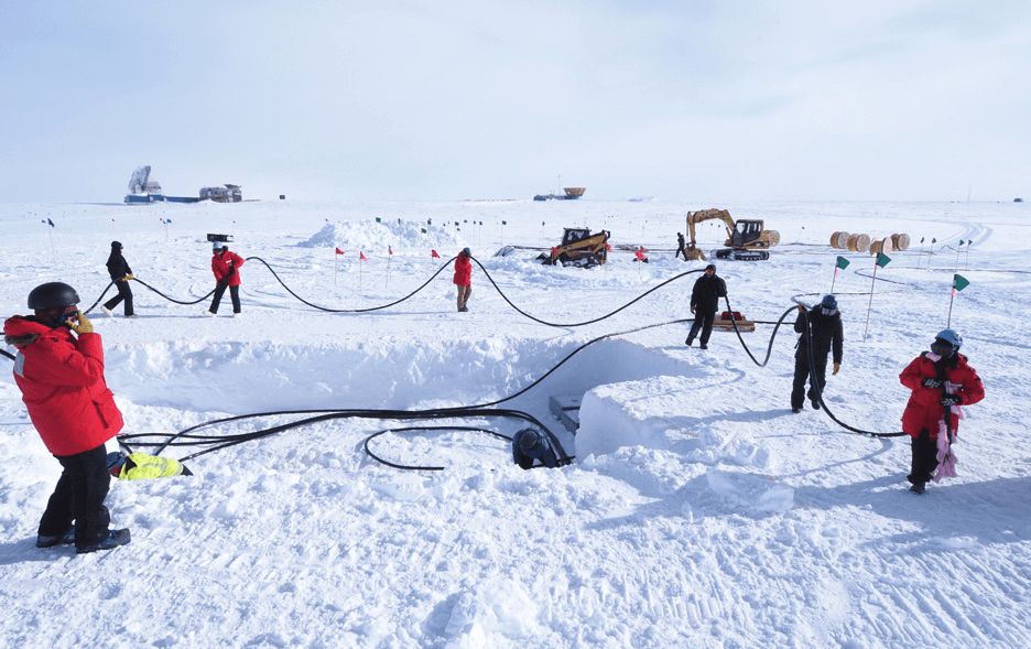 Workers handling cables in the snow at the South Pole