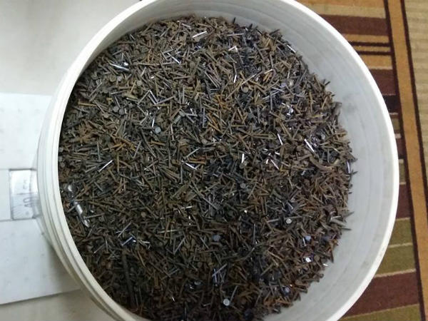 An engineer collect more than 50 kilograms of nails scattered over a road
