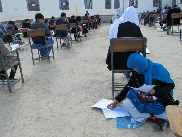 v25 year old Afghan woman takes exam while nursing her baby
