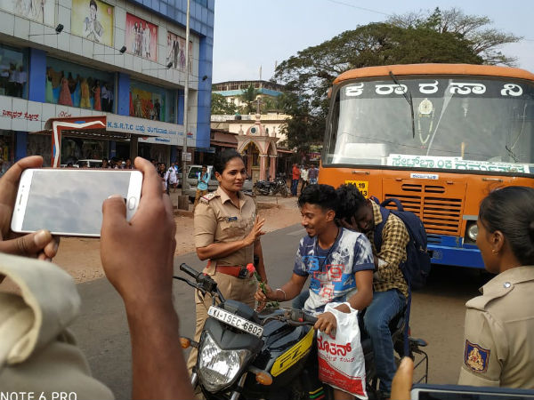 Lady police officer gave Rose to youth to were helmet Lady police officer gave Rose to youth to were helmet