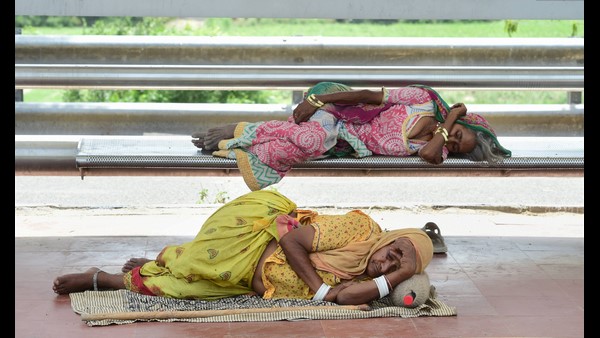 ನವದೆಹಲಿ ಬಸ್ ಶೆಡ್‌ನಲ್ಲಿ ವಿಶ್ರಾಂತಿ ಪಡೆದ ಕಾರ್ಮಿಕರು 