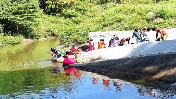 ಮುಖ್ಯ ರಸ್ತೆಯ ಕಾಲುವೆಯ ನೀರಿನಲ್ಲಿ ಭಕ್ತರ ಸ್ನಾನ